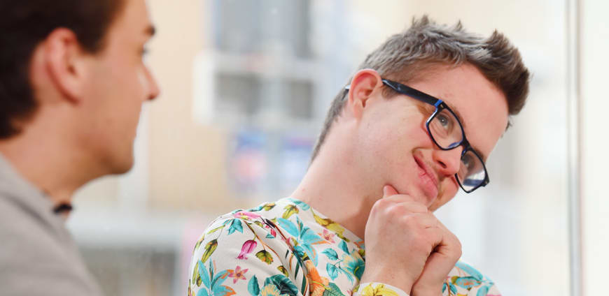 Vriendelijk lachende jongen met een beperking.