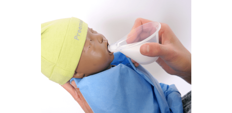 Voedingsschuitje waarmee een babypop melk krijgt