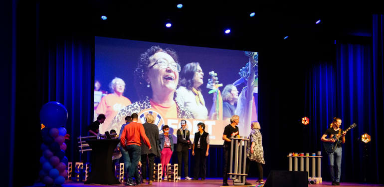 Podium gevuld met band en deelnemers uit het publiek