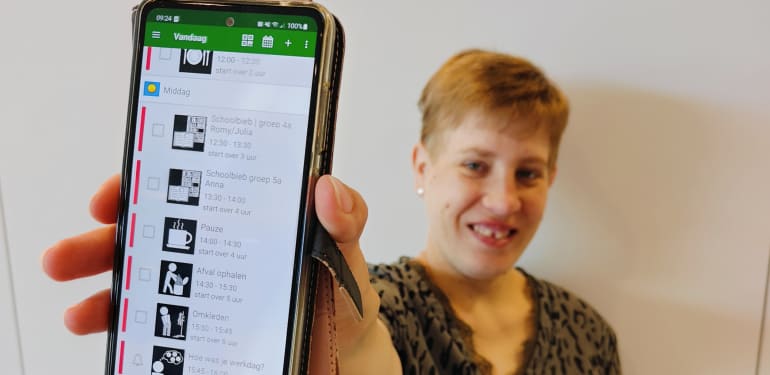 Client laat glimlachend het scherm van haar telefoon zien